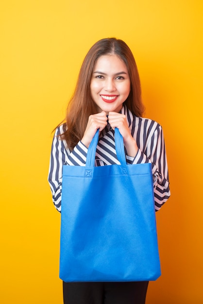 Schöne Frau hält blaue Stofftasche