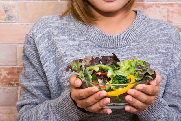 Schöne Frau hält eine Schüssel mit frischem Gemüsesalat