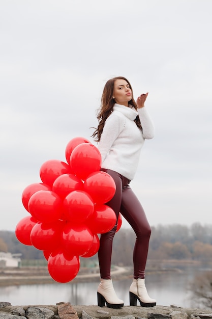 Schöne Frau hält einen Luftballons in ihren Händen