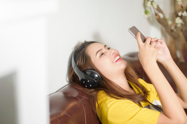 Schöne Frau hört Musik im Haus