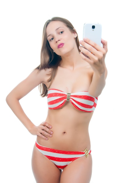 Schöne Frau im Bikini, die ein Selfie auf ihrem Handy macht