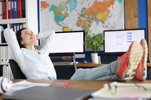 Schöne Frau im Büro träumt und schaut an die Decke