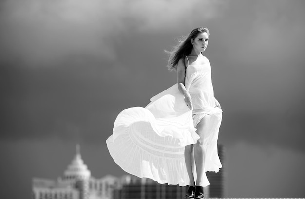 Schöne Frau im eleganten Kleid am Himmel. Weibliches Modell in einem modischen Kleid im Freien
