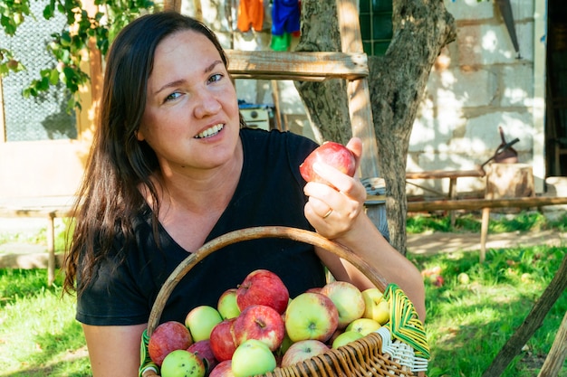 Schöne Frau im Garten mit Äpfeln