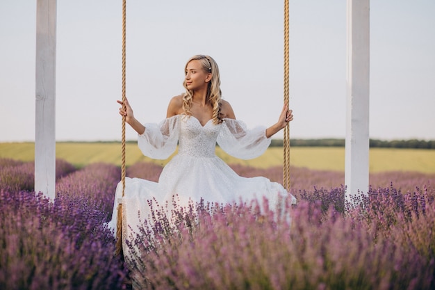 Schöne Frau im Hochzeitskleid im Lavendelfeld