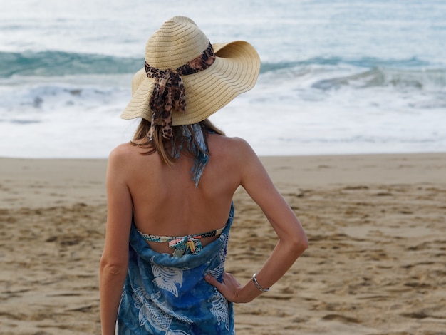 Schöne Frau im Hut am Strand.