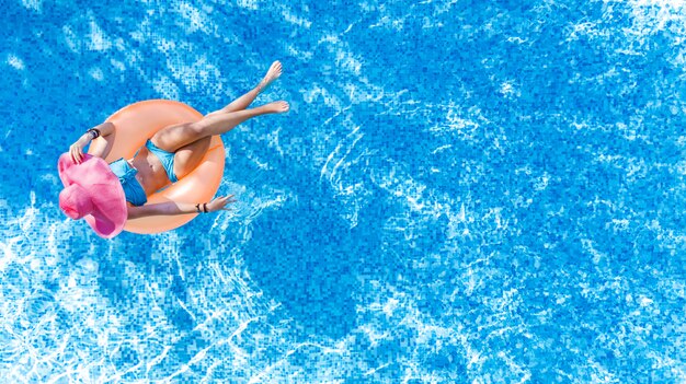 Schöne Frau im Hut in der Luftansicht des Schwimmbades von oben