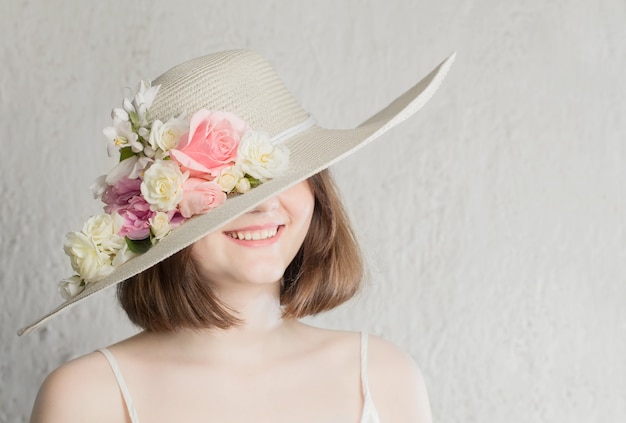 Schöne Frau im Hut mit Blumen