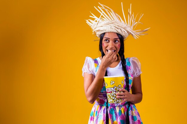 Schöne Frau im Juni-Party-Outfit, die Popcorn isst