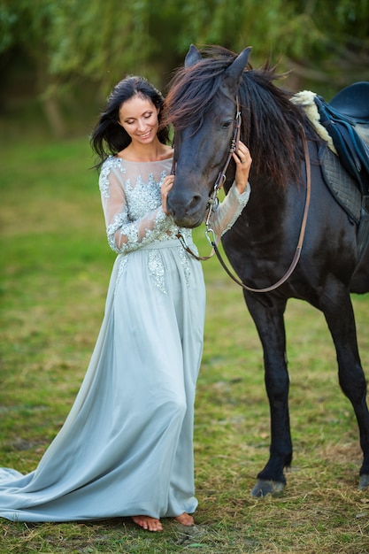 Schöne frau im kleid mit rappe in der natur