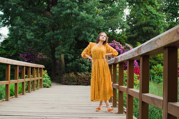 Schöne Frau im Sommer im gelben Kleid