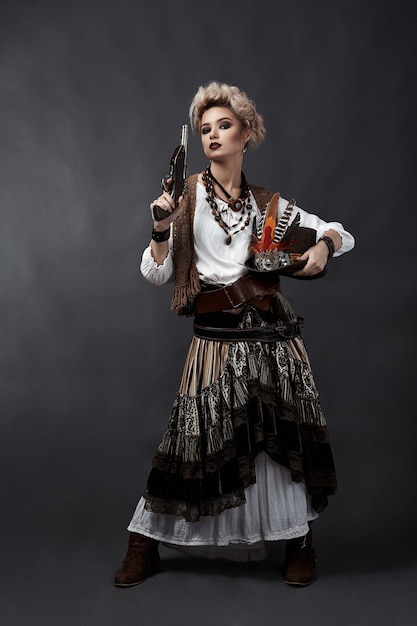 Schöne Frau im Steampunk-Stil Kostüm mit Hut und Pistole