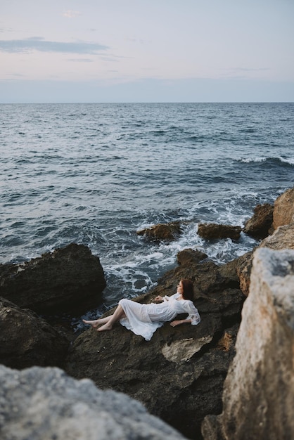 Schöne Frau im weißen Hochzeitskleid am Meer nasses Haar Urlaubskonzept