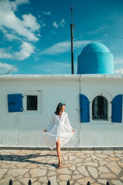 Schöne Frau im weißen Kleid in der Nähe der alten griechischen Kirche