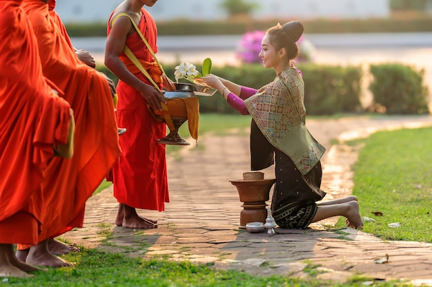 Schöne Frau in der alten laotischen Nationaltracht, die bereit sind, Verdienst zu machen