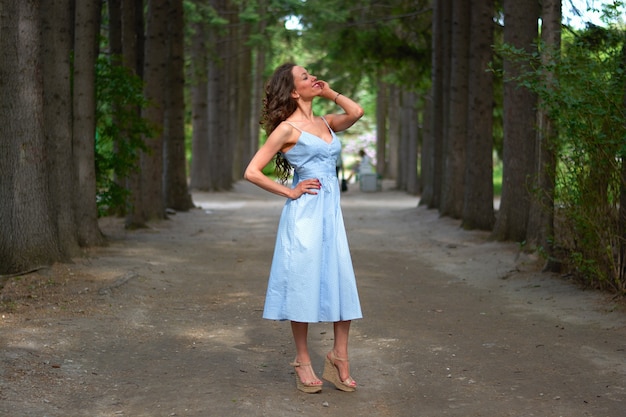 Schöne Frau in einem blauen Kleid im Park