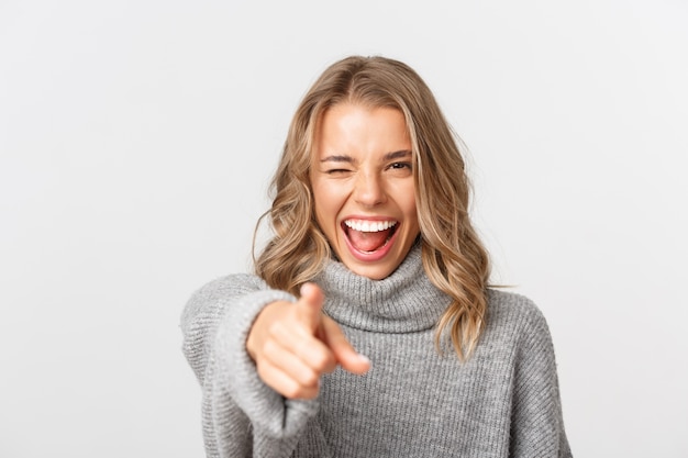 Schöne Frau in einem grauen Pullover, der aufwirft