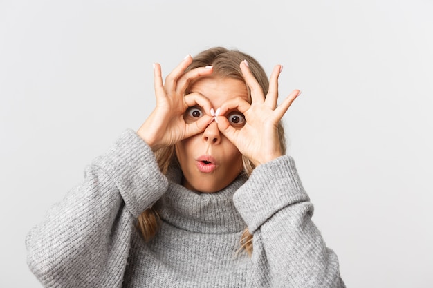 Foto schöne frau in einem grauen pullover, der aufwirft