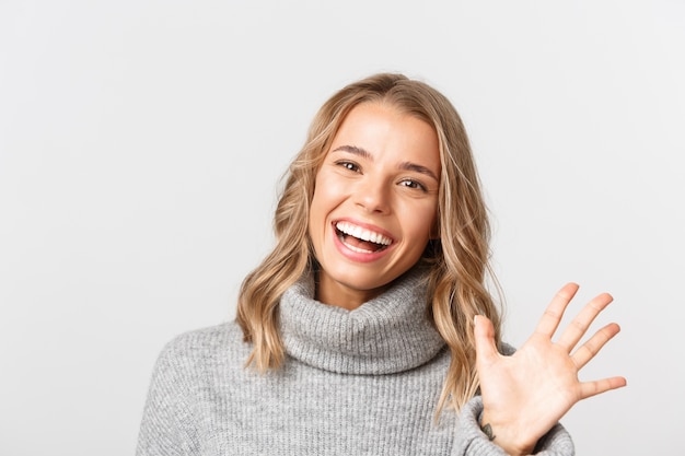 Schöne Frau in einem grauen Pullover, der aufwirft