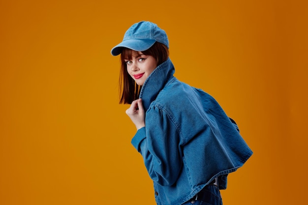 Schöne Frau in einer Mütze und Jeansjacke posiert als Studio-Modell unverändert Hochqualitätsfoto