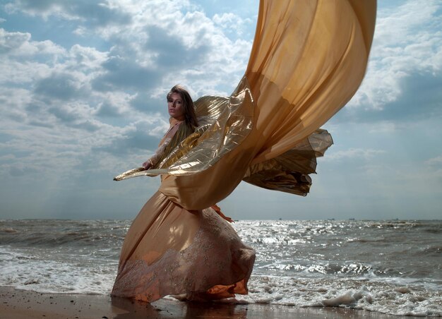 Schöne Frau in exotischem Kleid, die am Strand steht. Asowsches Meer