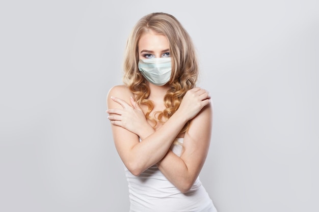 Schöne Frau in medizinischer Maske Porträt Mädchen trägt eine schützende Gesichtsmaske auf Weiß