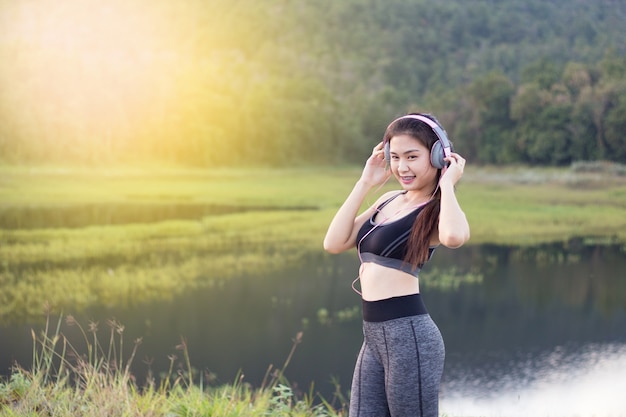 schöne Frau in Sportkleidung Musik auf Kopfhörer hören