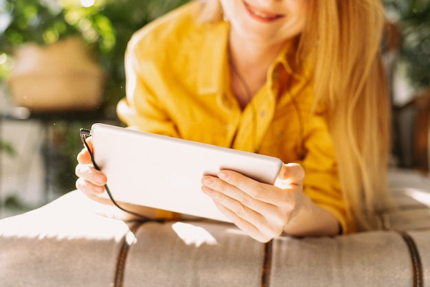 Schöne Frau kommuniziert mit Freunden unter Verwendung einer Tablette