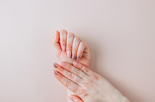 Schöne Frau Maniküre auf hellbeigem Hintergrund minimalistische Maniküre Trend Draufsicht flach liegen