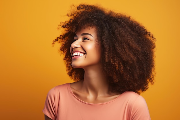 schöne Frau mit Afrohaaren, die auf einem hellen Hintergrund lächelt