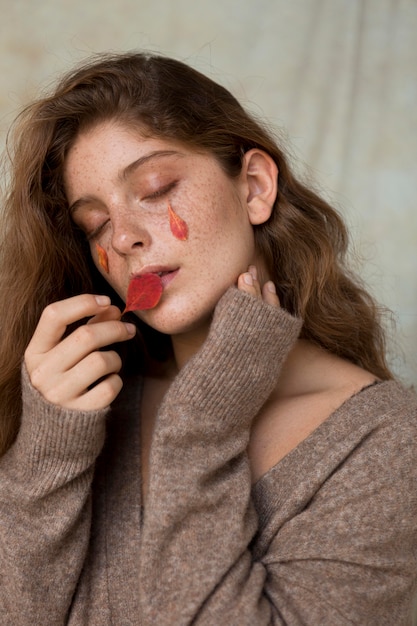 Foto schöne frau mit blättern auf gesicht und lippen