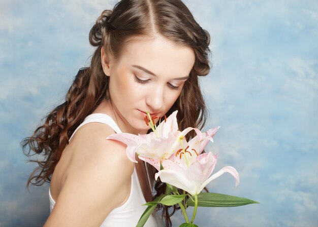 Schöne Frau mit Blumen einer Lilie