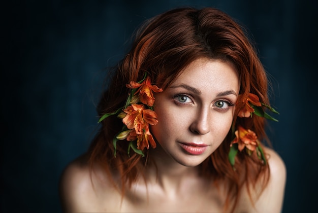 Schöne Frau mit Blumen. Gesicht Nahaufnahme. Make-up und Frisur