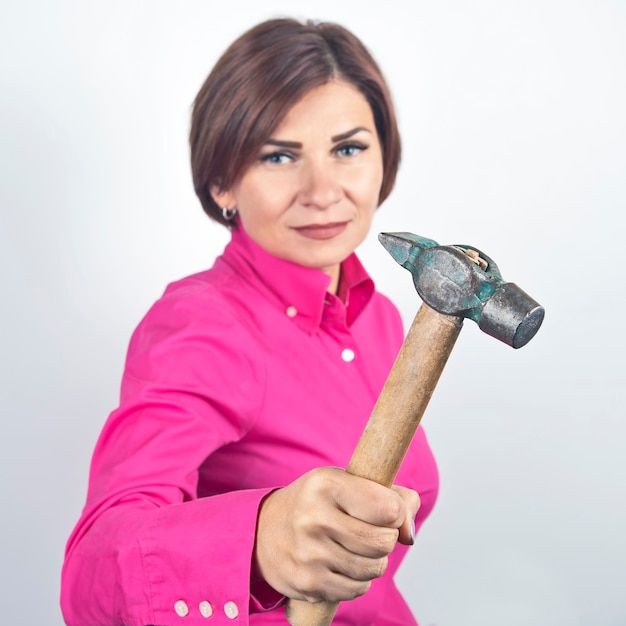 Schöne Frau mit einem Hammer in der Hand