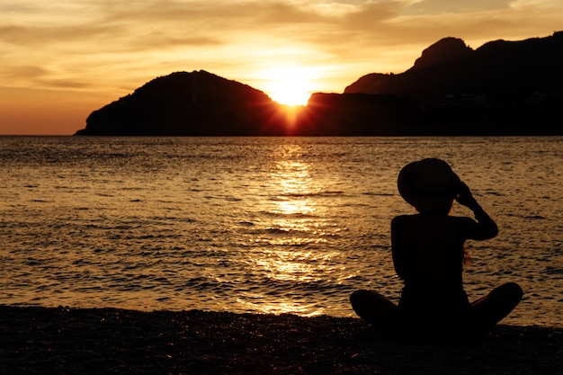 Schöne Frau mit einem Hut nahe dem Meer