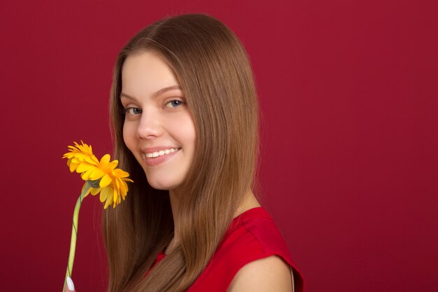 Schöne Frau mit einem roten Hemd und einer Blume