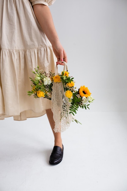 Schöne Frau mit frühlingsgelbem Blumenstrauß Frühlings- und Schönheitskonzept