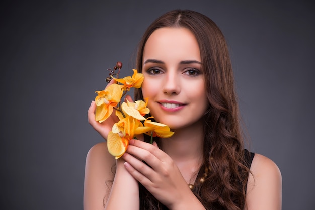 Schöne Frau mit gelber Orchideenblume