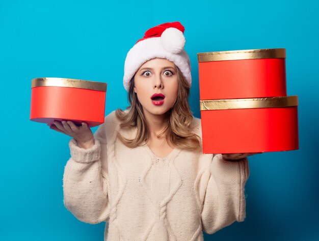 Schöne Frau mit Geschenkbox auf blauer Wand