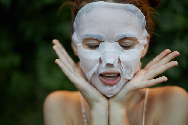 Schöne Frau mit geschlossenen Augen zeigt Zunge Anti-Falten-Maske Dermatologie