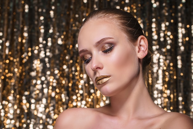 Schöne Frau mit goldenem Make-up