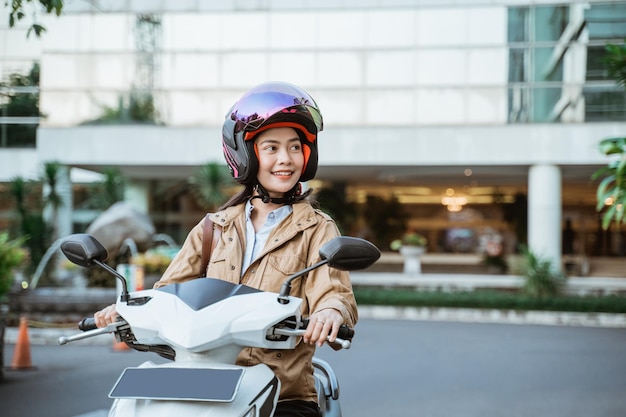 Schöne Frau mit Helm beim Motorradfahren auf der Straße