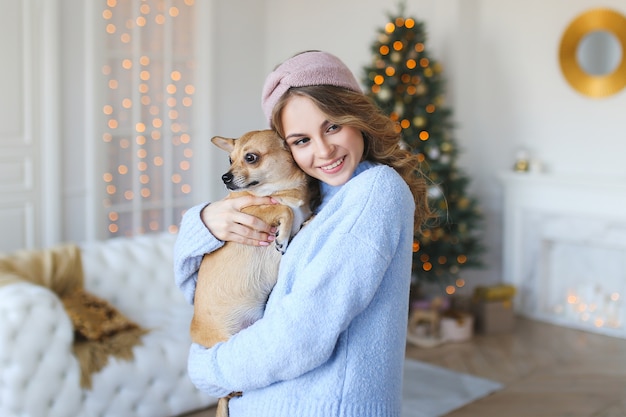 Schöne Frau mit Hund an Weihnachten zu Hause