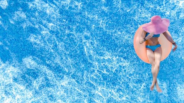 Foto schöne frau mit hut im schwimmbad, drohnenaufnahme von oben, junges mädchen im bikini entspannt sich