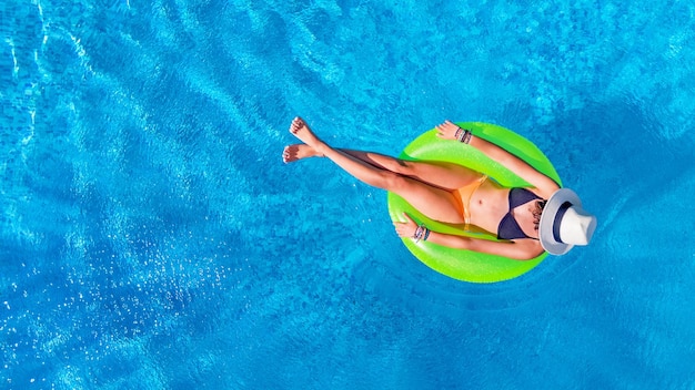 Foto schöne frau mit hut im schwimmbad, drohnenaufnahme von oben, junges mädchen im bikini entspannt sich