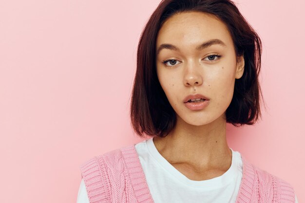 Schöne Frau mit kurzen Haaren und einem rosa Pullover isoliert Hintergrund