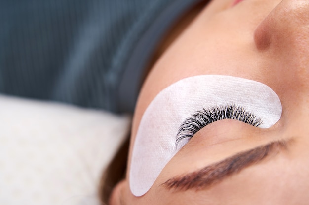 Schöne Frau mit langen Wimpern in einem Schönheitssalon Wimpernverlängerungsverfahren