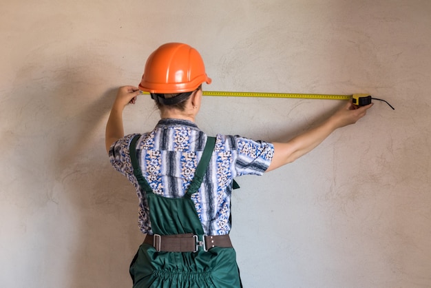 Schöne Frau mit Meter in Schutzuniform