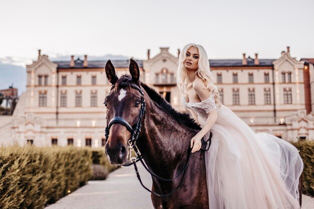 Schöne Frau mit Pferd nahe Schloss