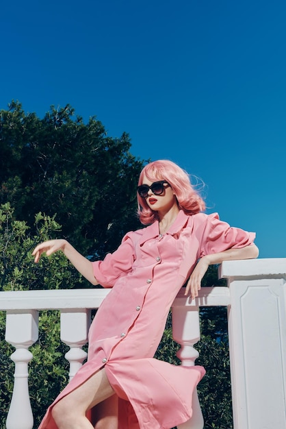 Schöne Frau mit rosa Haaren mit Sonnenbrille posiert Sommertag